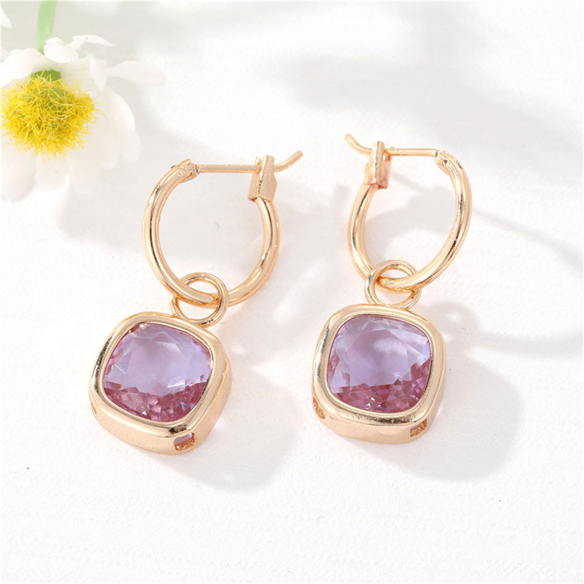 Stunning purple crystal and gold-plated cube huggie earrings, ideal for elevating any outfit with a pop of color.