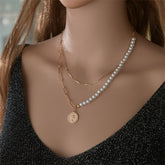 Elegant 18K gold-plated coin pendant layered with a pearl chain, showcasing a refined and stylish necklace design.