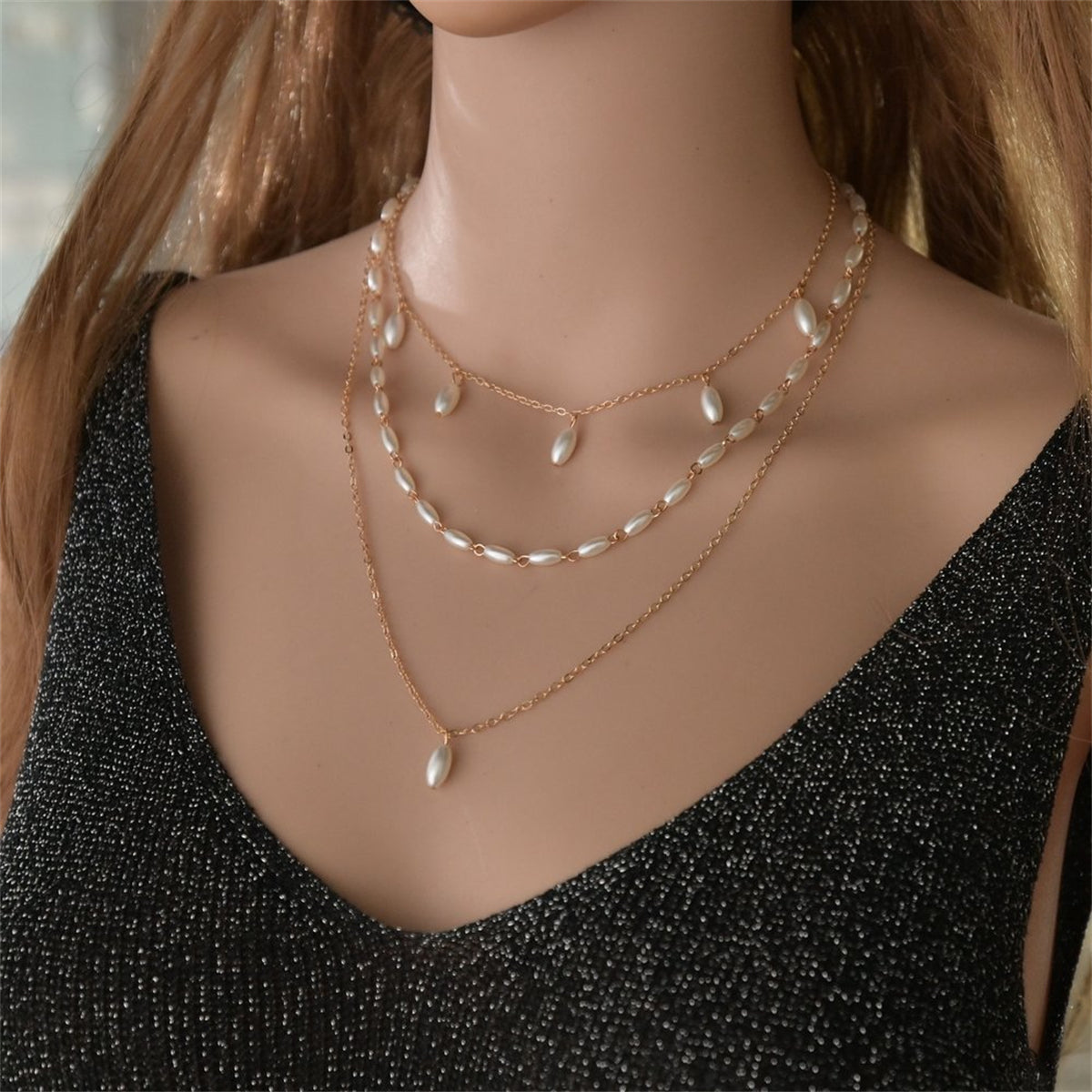 Elegant three-strand pearl necklace with 18K gold-plated accents, showcasing timeless sophistication and luxury.