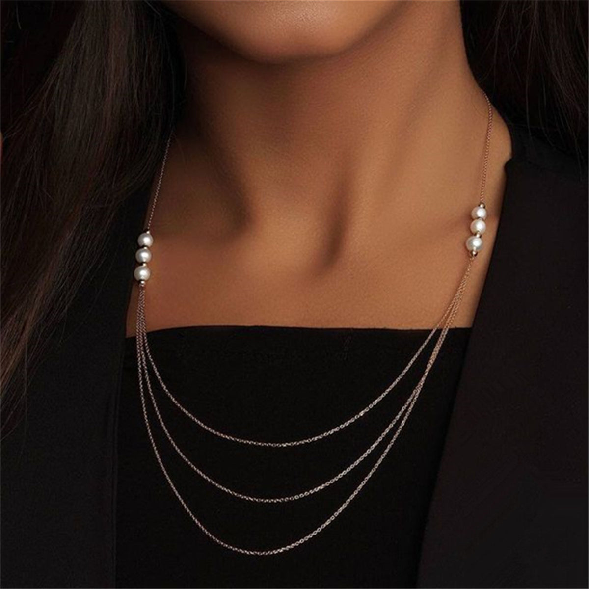 A layered pearl and 18K gold-plated necklace featuring three rows of sparkling diamonds.