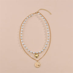 A stunning layered necklace with a heart and sun coin, crafted from 18K gold plating and adorned with pearls.