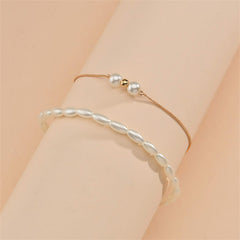 A sophisticated gold chain anklet with a pearl and gold beads, designed as part of an 18K gold-plated anklet set.