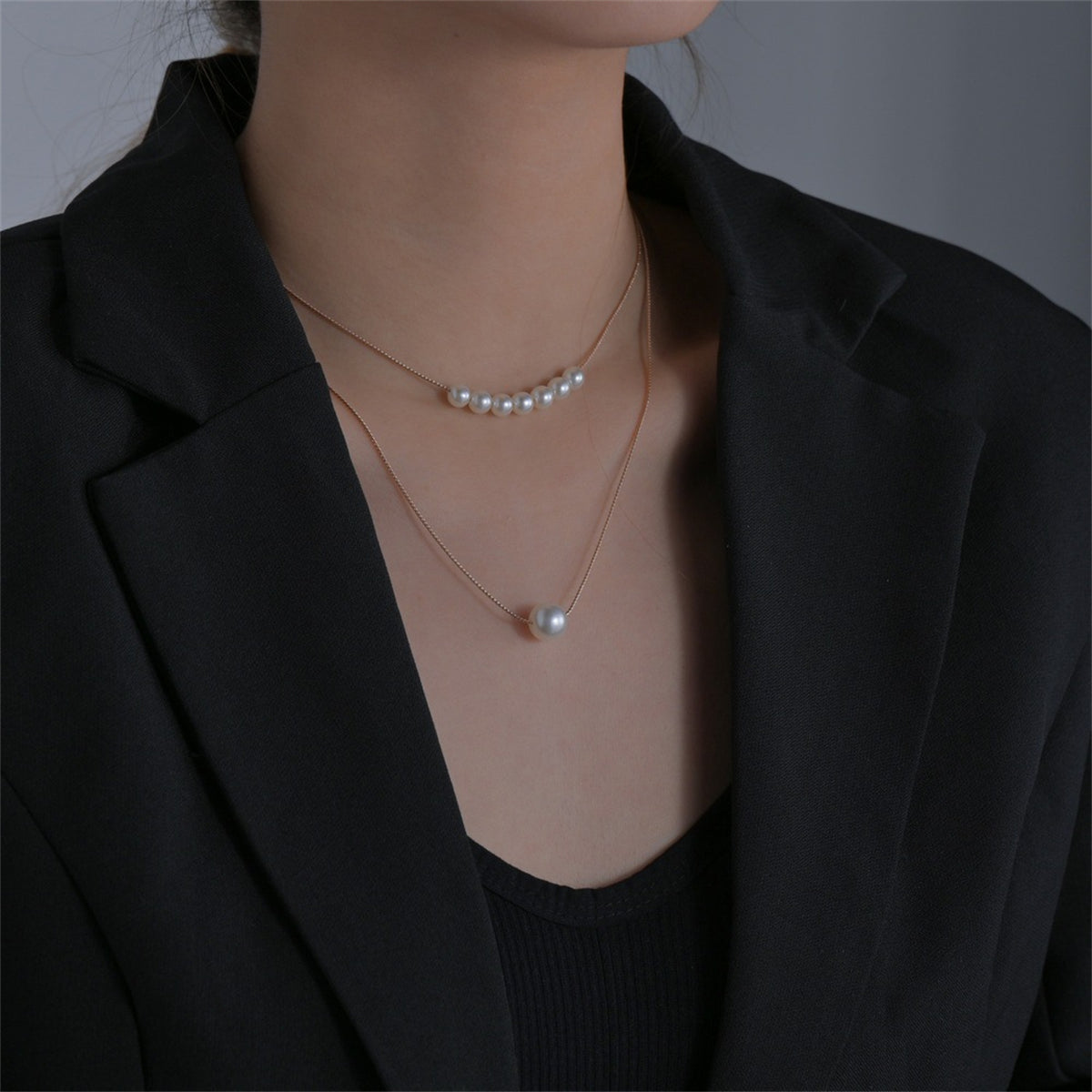 Two layers of lustrous pearls elegantly draped on a gold chain, showcasing a pearl and 18K gold-plated beaded necklace.