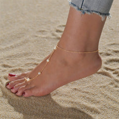 A gold chain anklet adorned with pearls, showcasing elegance and sophistication in a stylish design.