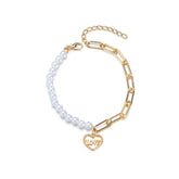 Elegant white pearl bracelet adorned with a gold heart charm, representing love and timeless beauty.