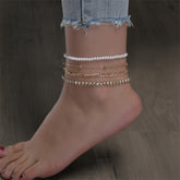 Elegant three-strand gold chain anklet featuring pearls, included in a luxurious four-piece beaded anklet set.