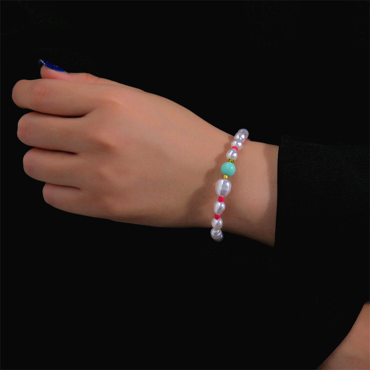 A Howlite and Turquoise beaded station bracelet featuring pink and white beads on a gold chain.