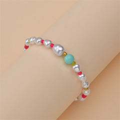 A stylish bracelet made of pink and white beads, adorned with a gold chain, highlighting Howlite and Turquoise.