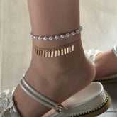 Elegant gold chain bracelet embellished with white pearls, showcasing a refined gold chain aesthetic.