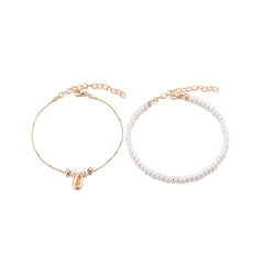 A duo of anklets with pearls and gold chains, elegantly designed as a pearl and 18K gold-plated shell charm anklet set.