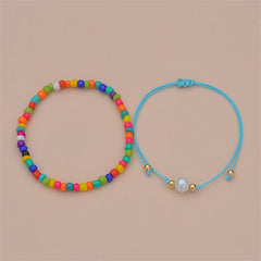 Two vibrant anklets with rainbow beads and a blue cord, showcasing the Red Multicolor Howlite Stretch Anklet Set.