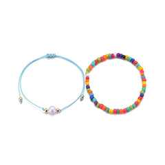 A set of two anklets featuring rainbow beads and a blue cord, part of the Red Multicolor Howlite Stretch Anklet Set.