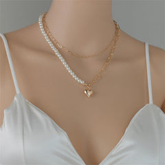 An 18K gold-plated necklace adorned with a heart charm and a pearl, showcasing a refined and elegant design.