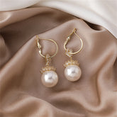 Elegant 18k gold-plated floral huggie earrings featuring white pearls and sparkling cubic zirconia crystals.
