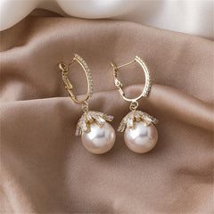 Elegant 18K gold-plated huggie earrings featuring white pearls and sparkling cubic zirconia accents.