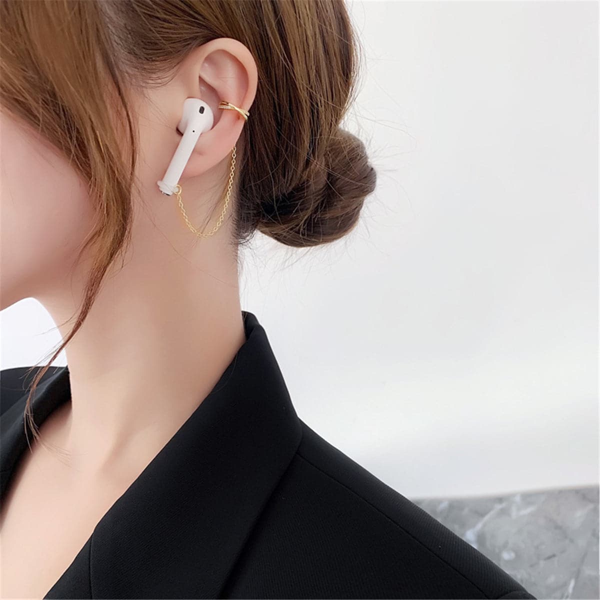 Elegant gold-plated earring with a pearl centerpiece and crisscross design, enhanced by cubic zirconia.