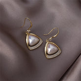 Gold-plated open-triangle drop earrings featuring white cubic zirconia stones and a pearl accent.