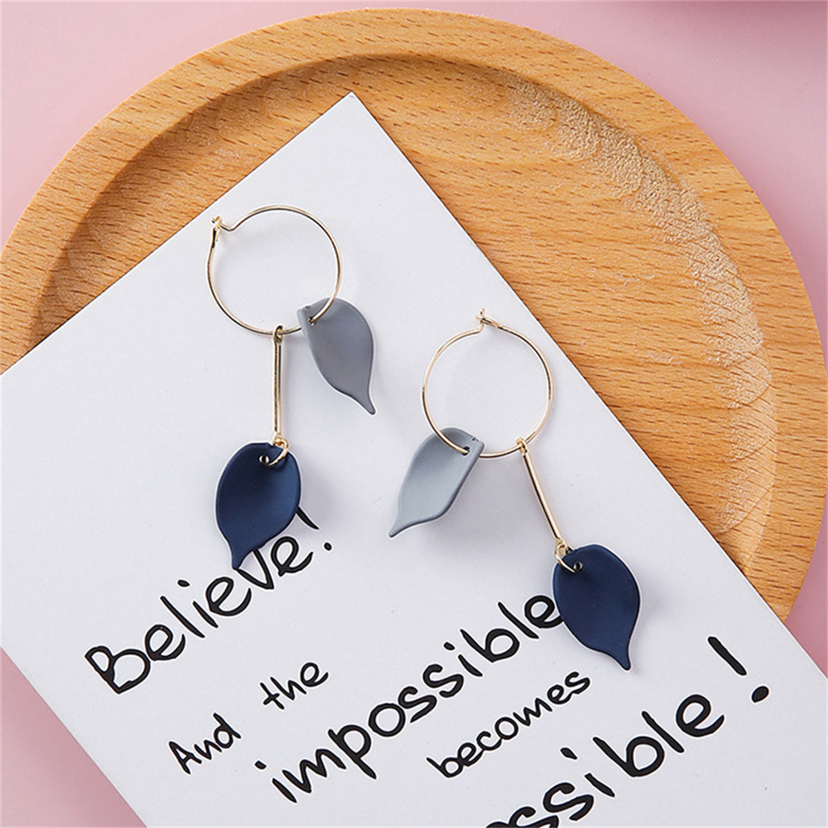 Two pairs of earrings featuring blue acrylic and 18K gold-plated leaves, showcasing a stylish and nature-inspired design.