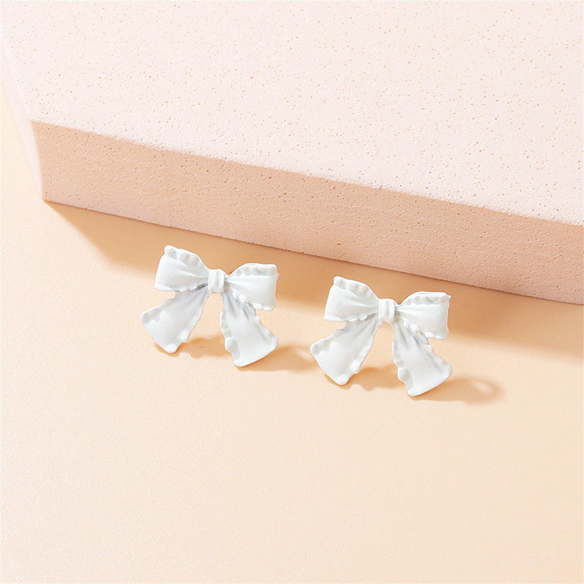 White Enamel and Silver-Plated Bow Stud Earrings, silver stud earrings for women, dainty minimalist design, front view