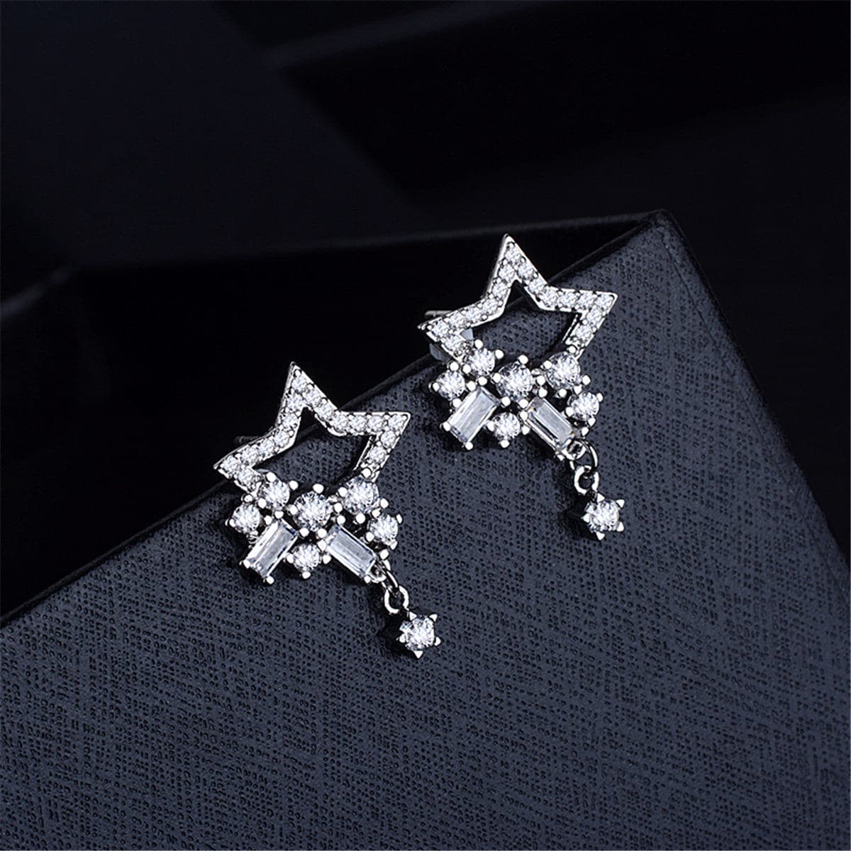 Silver star cluster drop earrings adorned with sparkling cubic zirconia diamonds.