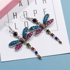 Vibrant dragonfly drop earrings in blue and pink crystals, elegantly designed with silver-plated accents and detailed wings.