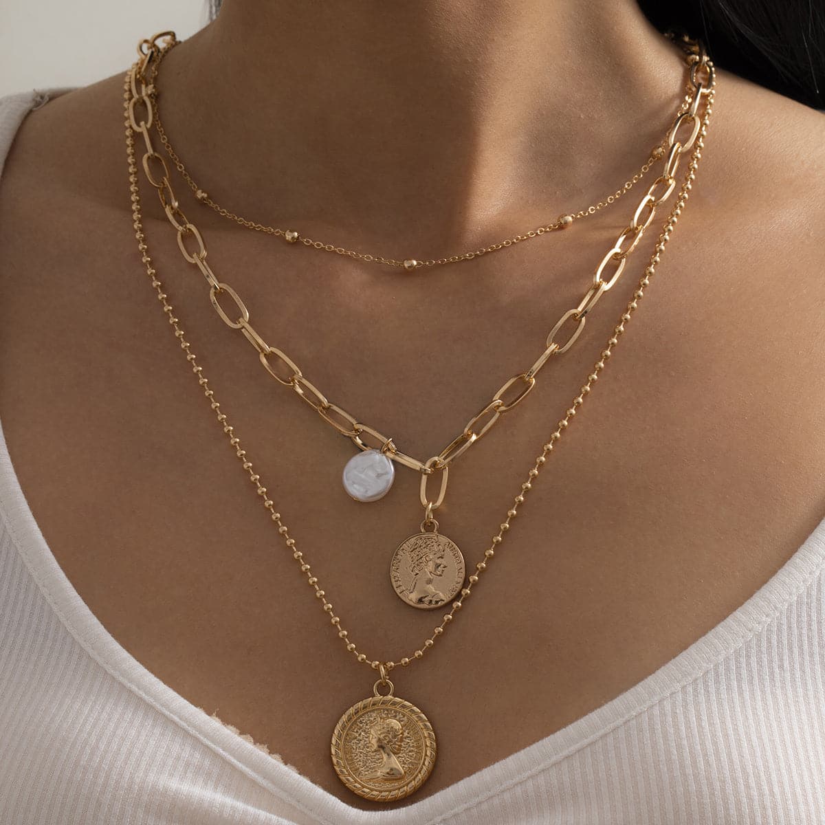 Layered pearl and 18K gold-plated necklace featuring a coin pendant and delicate cable chain design.