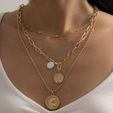 Layered pearl and 18K gold-plated necklace featuring a coin pendant and delicate cable chain design.
