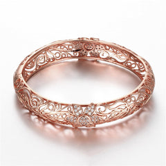 Beautiful rose gold bracelet showcasing an intricate filigree flower pattern, embellished with cubic zirconia.