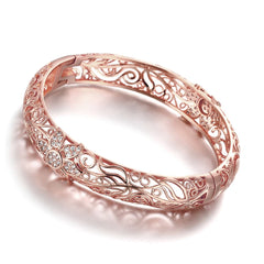 Elegant rose gold bracelet featuring intricate filigree flower design with sparkling cubic zirconia accents.