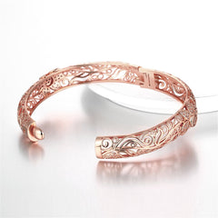 Exquisite rose gold-plated bangle with a delicate filigree flower design, enhanced by sparkling cubic zirconia.