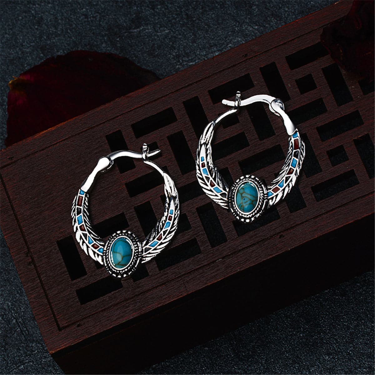 Turquoise and silver-plated feather hoop earrings featuring turquoise stones and intricate silver detailing.