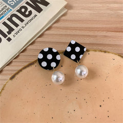 Stylish black and white polka dot earrings with a pearl, featuring a unique geometric mismatched design.