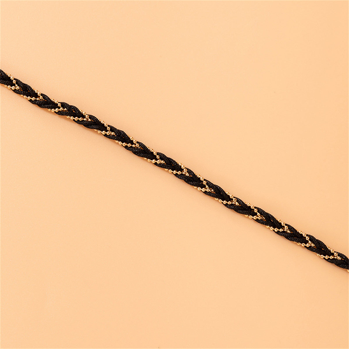 Trendy black braided bracelet enhanced with a striking 18K gold-plated chain, perfect for elevating your accessory game.