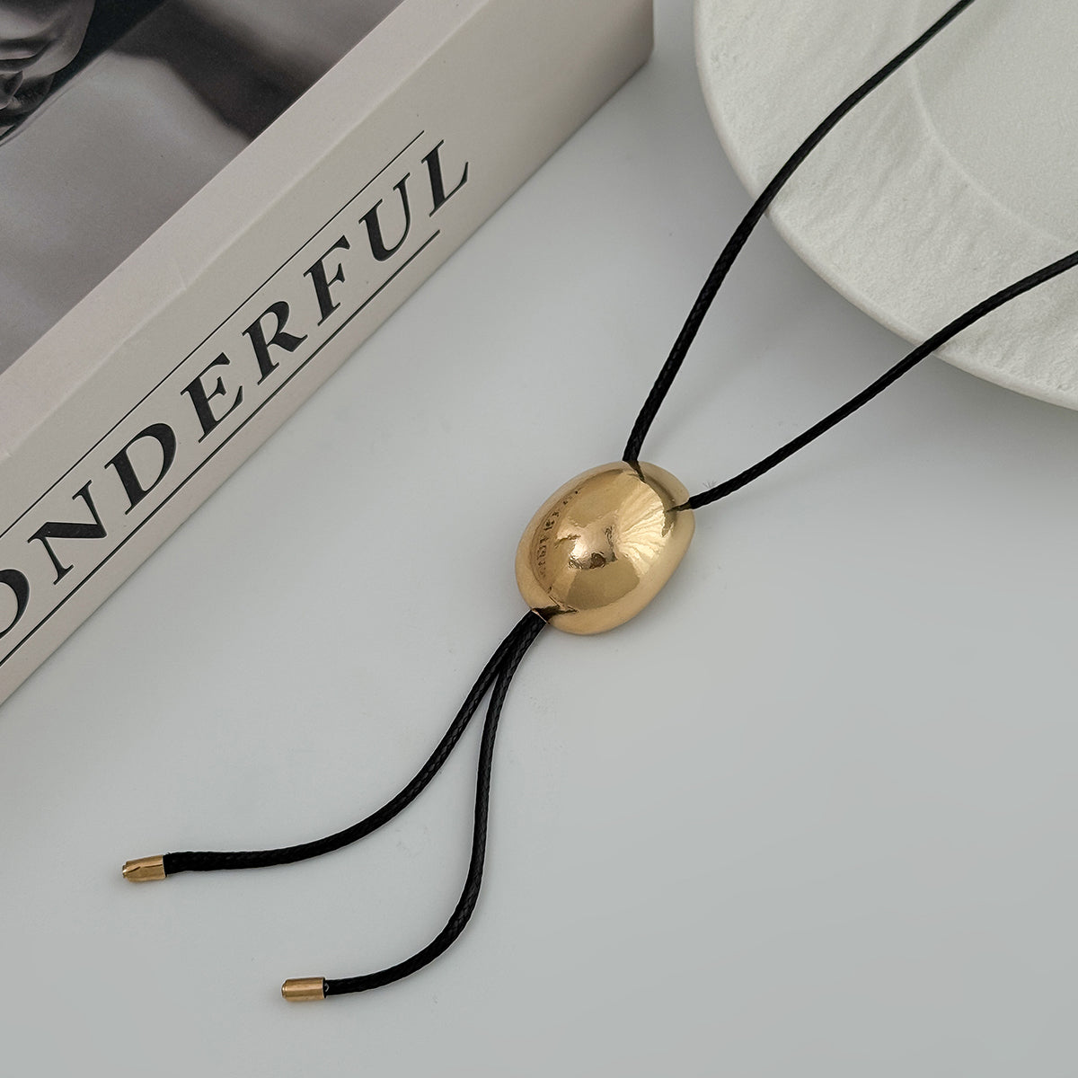Black Polyster and Goldtone Oval Tassel Necklace, botanical inspired, side view