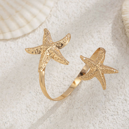 Goldtone Hammered Dual-Starfish Bypass Arm Cuff, dainty minimalist design, detail close-up