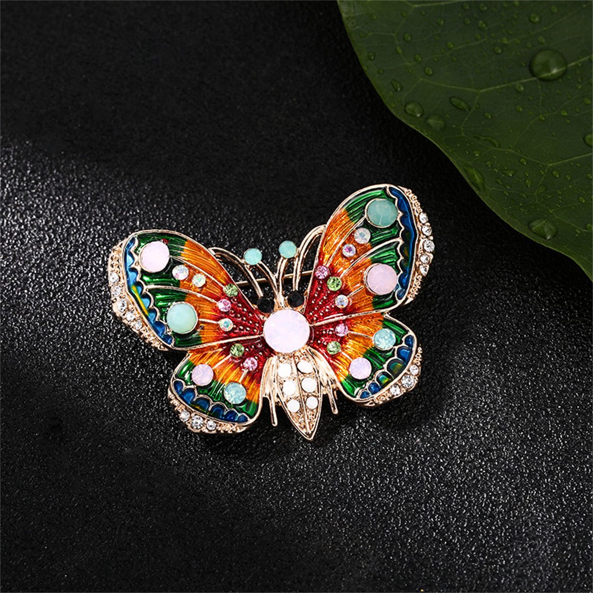 Elegant butterfly brooch in 18K gold plating, embellished with colorful stones, ideal for a touch of charm and sophistication.