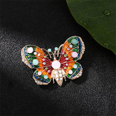 Elegant butterfly brooch in 18K gold plating, embellished with colorful stones, ideal for a touch of charm and sophistication.