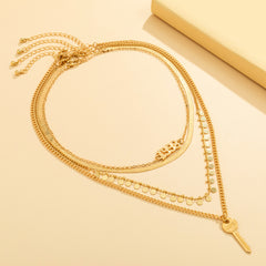Stunning layered gold chain necklace with a key charm, perfect for adding a unique flair to any outfit.