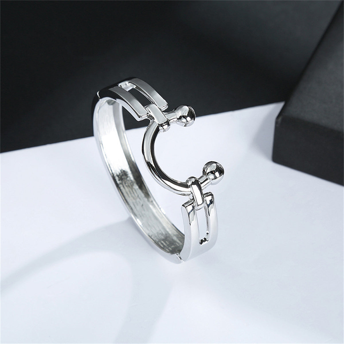 Elegant silver-plated saddle bangle showcasing a ring adorned with two side balls for added flair.