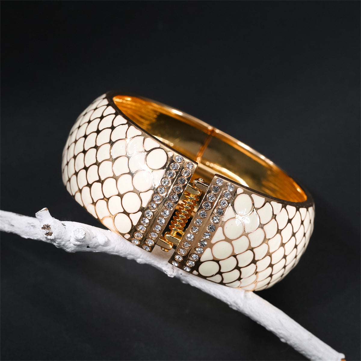 A stylish white snake skin bracelet with gold accents, featuring apricot enamel and cubic zirconia in an 18K gold-plated finish.