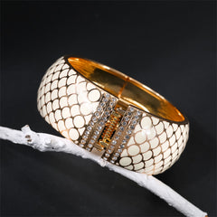A stylish white snake skin bracelet with gold accents, featuring apricot enamel and cubic zirconia in an 18K gold-plated finish.