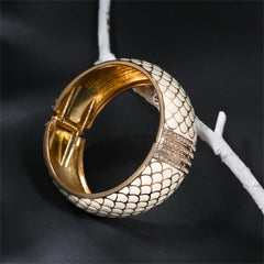 White snake skin bracelet with gold accents, showcasing apricot enamel and cubic zirconia, crafted in 18K gold plating.