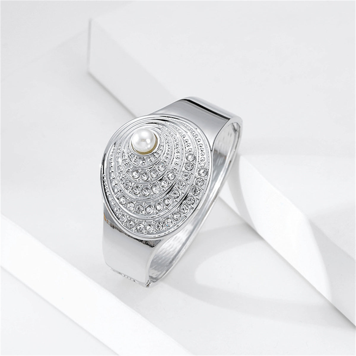 Silver bangle showcasing a pearl and diamond design, paired with a cubic zirconia and pearl silver-plated shell bangle.