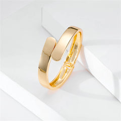 Fashionable 18K gold-plated bangle bracelet with a sleek bypass hinge and two smooth, curved edges for a sophisticated touch.