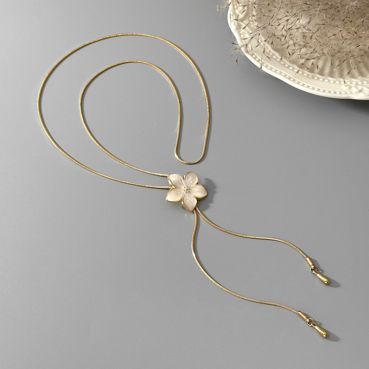 White Enamel and Goldtone Flower Tassel Pendant Necklace, botanical inspired, side view