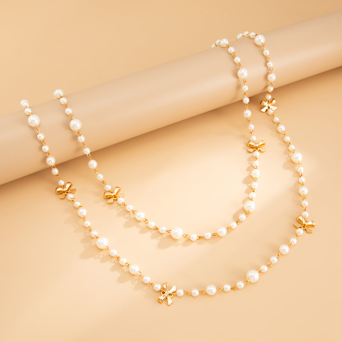Pearl and Goldtone Bow Station Long Necklace Set, gold pendant necklace for women, dainty minimalist design, side view