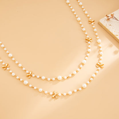 Pearl and Goldtone Bow Station Long Necklace Set, gold pendant necklace for women, dainty minimalist design, detail close-up