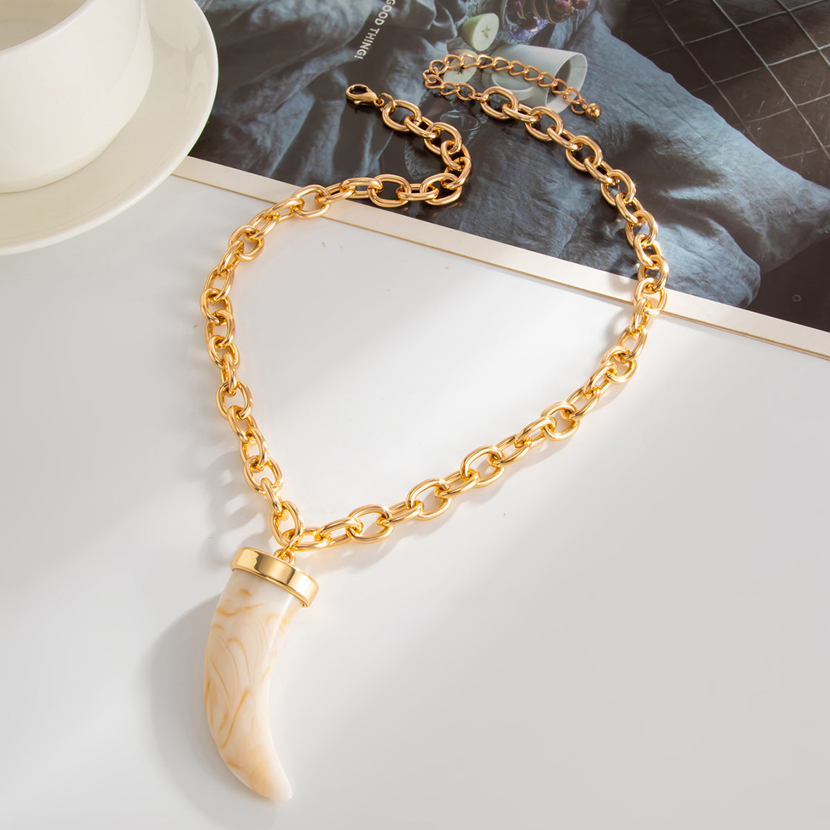 White Resin and Goldtone Wolf Tooth Pendant Necklace, dainty minimalist design, side view