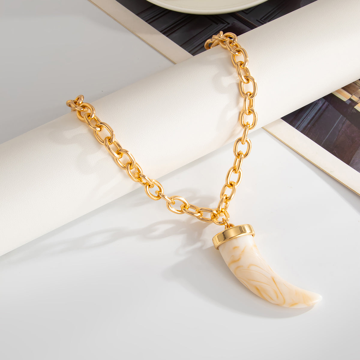 White Resin and Goldtone Wolf Tooth Pendant Necklace, dainty minimalist design, detail close-up