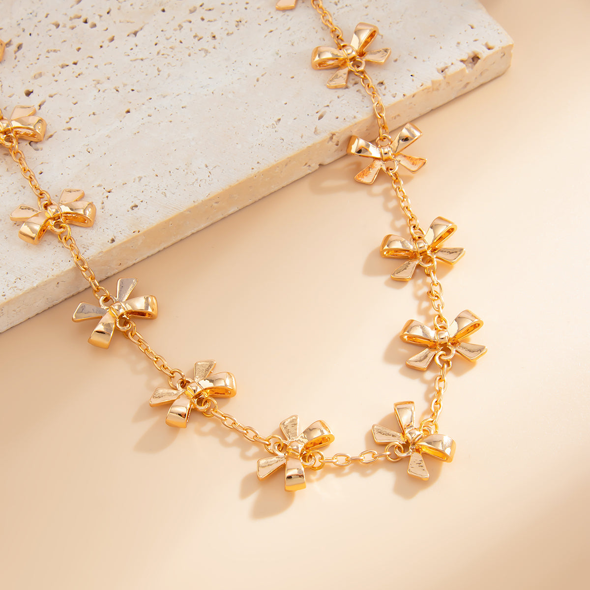 Goldtone Bow Station Lariat Necklace, botanical inspired, detail close-up